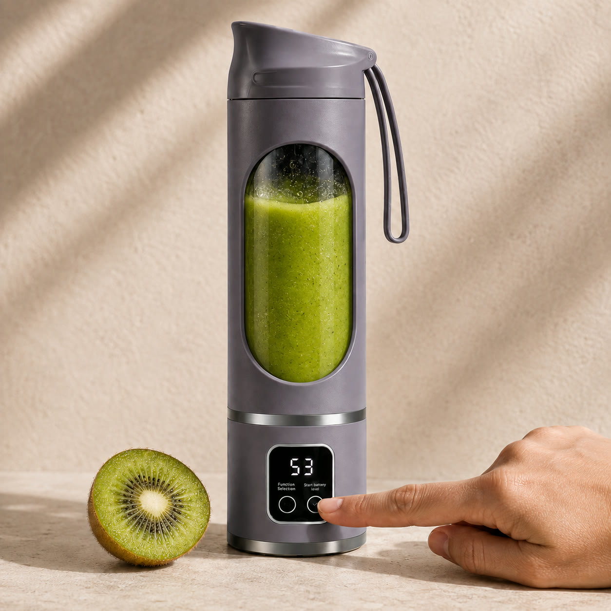 Grey Fruvia blender with a green kiwi smoothie and half a kiwi beside it